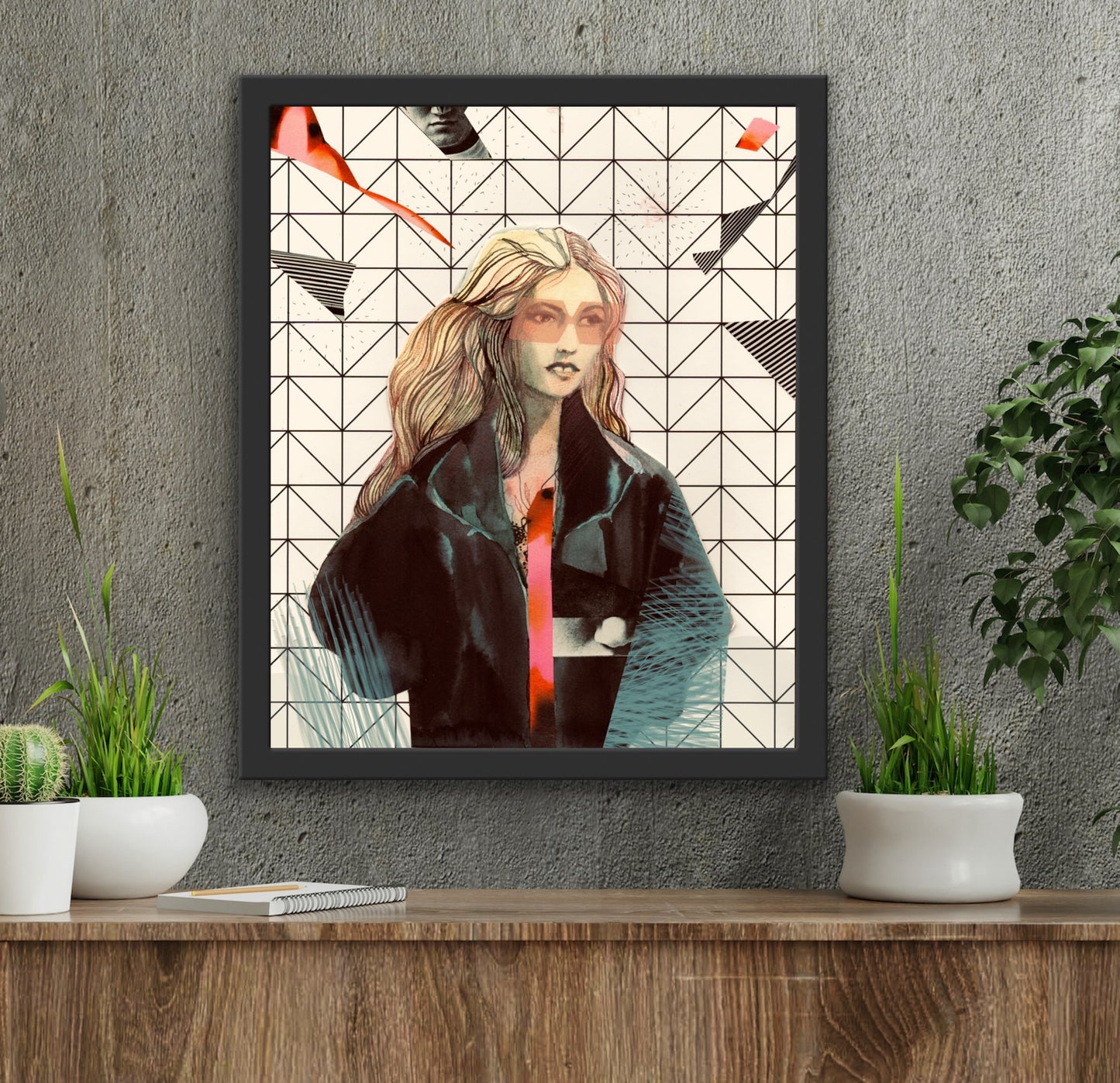 a framed artwork of a blond woman wearing glasses in a leather jacket with an abstract background, hangs on a dark grey wall above a dresser